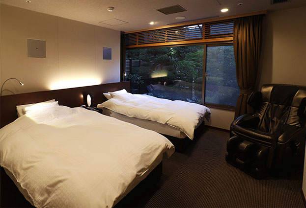 画像:ベッドルームのツインベッドとマッサージチェア